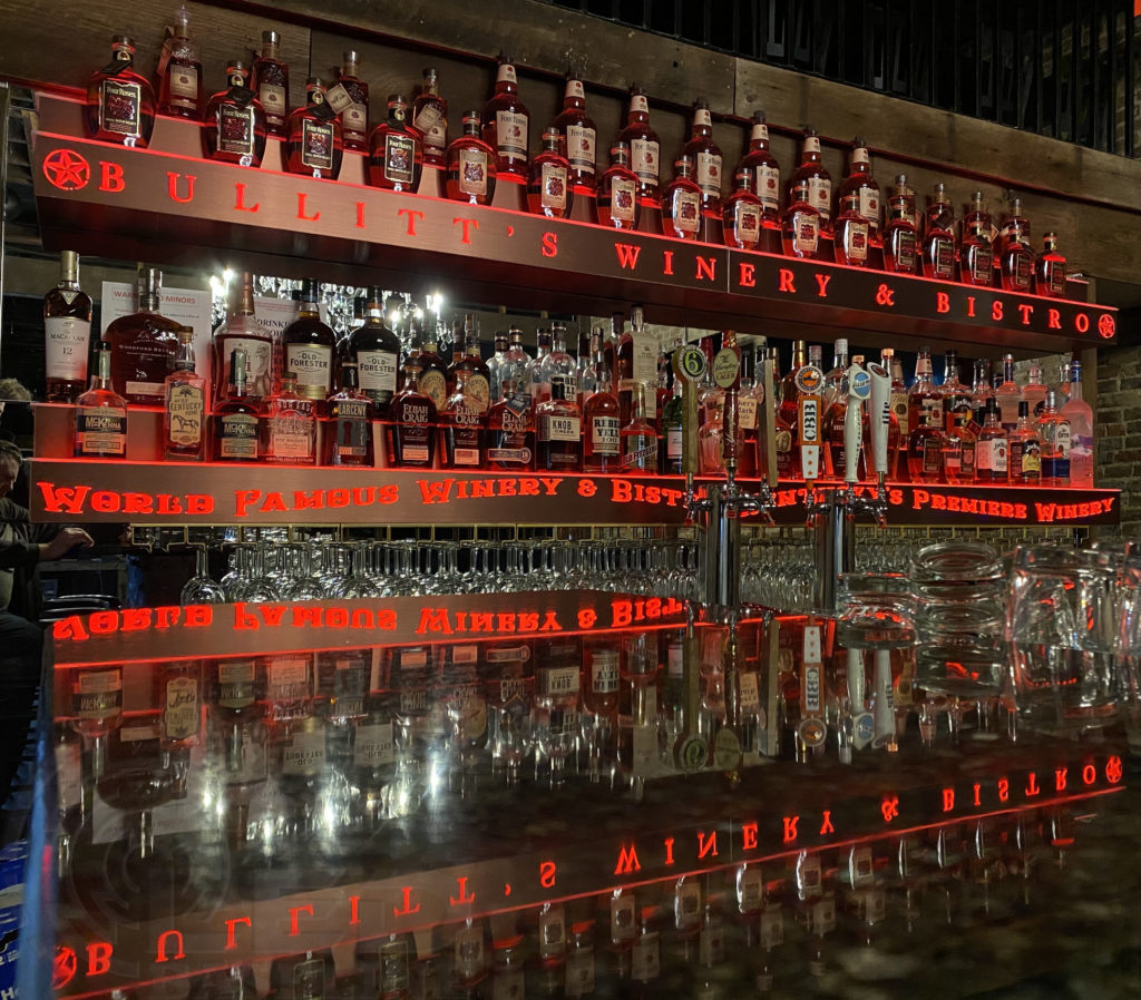 LED bar shelving with red lighting highlighting liquor bottles in a commercial backbar display