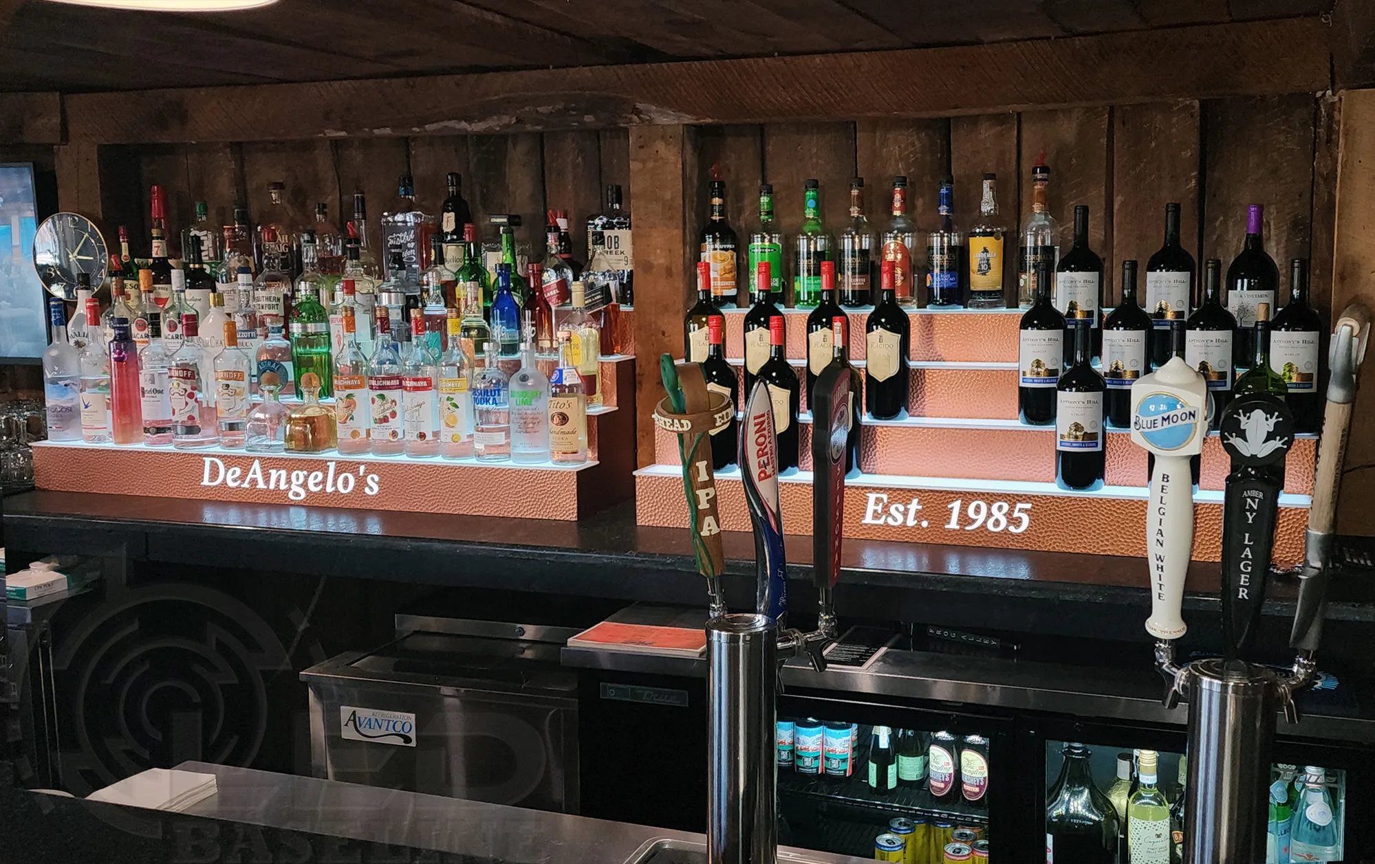 LED liquor shelves installed behind a bar with beer taps centered and illuminated bottle display on both sides